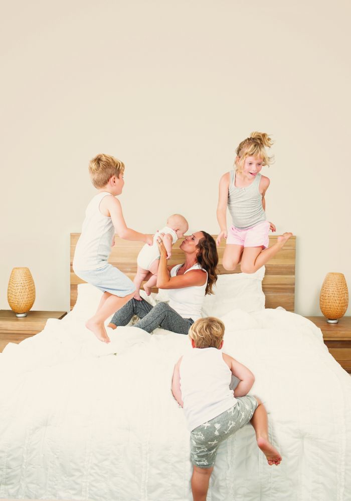 Sophie and her four children playing on the bed, from the Sleep Play Love book cover shoot